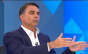 Flávio Bolsonaro repete tática do pai e exibe palavras anotadas na mão durante sabatina na Globo