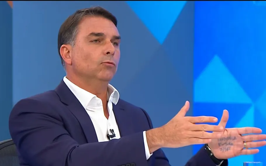 Flávio Bolsonaro repete tática do pai e exibe palavras anotadas na mão durante sabatina na Globo